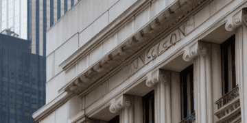 A building with columns and a skyscraper in the background, representing stability in the banking system.