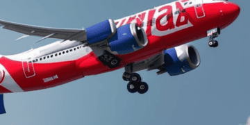 In Malaysia, an Aviation Business proudly presents a Capital A- red and white airplane flying gracefully in the sky.