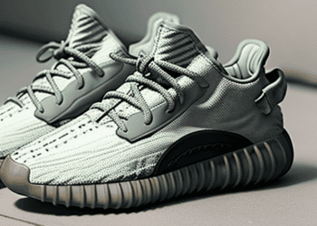 A pair of green Adidas sneakers, part of the Yeezy merchandise collection, displayed on a floor.