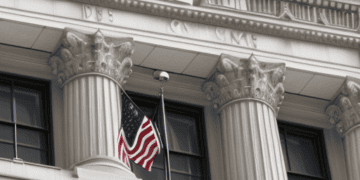 Two American flags hanging on the side of a building symbolize national unity amidst the potential consequences of a US debt default.