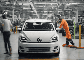 Volkswagen Golf production line worker inspecting a new white Golf. 2023 sales surge. - Supply Chain News