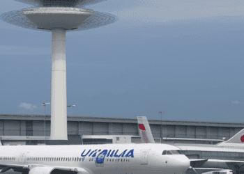 A white and blue airplane on the tarmac at Manila Airport.