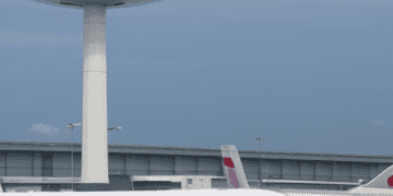 A white and blue airplane on the tarmac at Manila Airport.