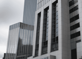 A tall building with a blue sign, owned by Deutsche Bank.