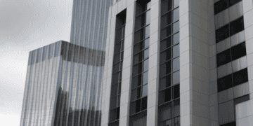 A tall building with a blue sign, owned by Deutsche Bank.