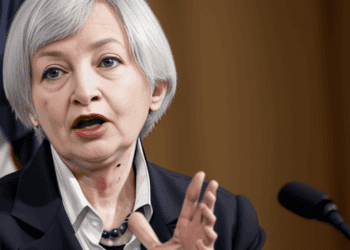 Treasury Secretary Yellen is speaking into a microphone, discussing the economic consequences.