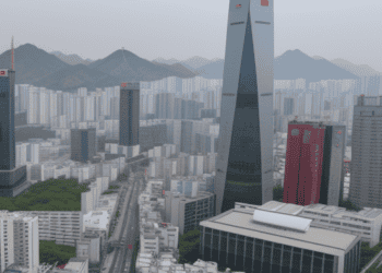 An aerial view of a city with tall buildings and mountains in South Korea, showcasing the growth and booming economy of the country.