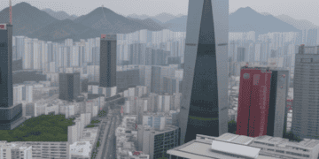 An aerial view of a city with tall buildings and mountains in South Korea, showcasing the growth and booming economy of the country.