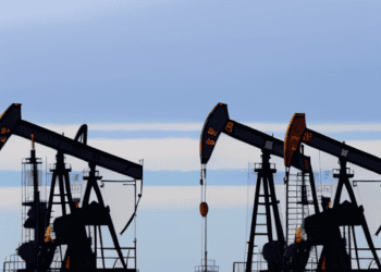 A group of oil pumps in the middle of a field, amidst Global Economic Concerns.