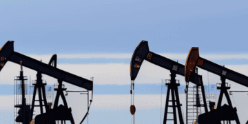 A group of oil pumps in the middle of a field, amidst Global Economic Concerns.