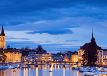 Night view of Zurich, Switzerland, showcasing the city's illuminated architecture and river. - Supply Chain News