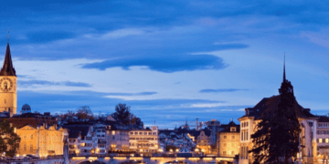 Night view of Zurich, Switzerland, showcasing the city's illuminated architecture and river. - Supply Chain News