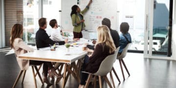 A group of people sitting around a table in a conference room, engaged in a collaborative discussion on North American Trade.