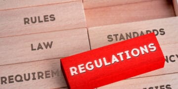 A red sign with the word regulations stacked on top of wooden blocks, highlighting the $13 Million Settlement.