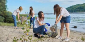 A group of youth-centric girls are picking up trash on the beach as part of a sustainability summit organized by the Bajaj Foundation.