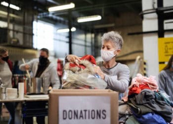 A woman, possibly a UN official, is putting clothes into a box.