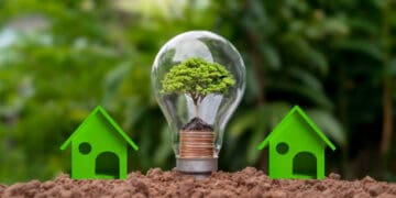 A light bulb with a tree and houses in the ground, highlighting the importance of Critical Raw Materials in Trade Agreements within the European Union.