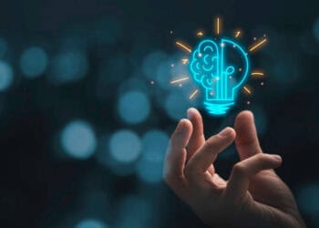 A hand holding a light bulb on a dark background illuminating human rights concerns in China amidst US trade sanctions.