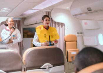 Two female flight attendants standing in an airplane equipped with SkyUp uniforms.
