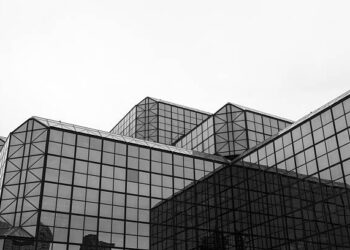 A black and white photo of a building with glass windows in New York City.