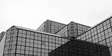 A black and white photo of a building with glass windows in New York City.
