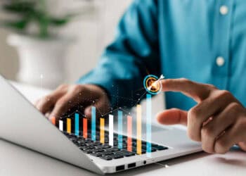 A man from Australia is using a laptop with a graph on it.