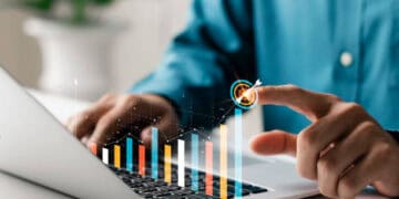 A man from Australia is using a laptop with a graph on it.