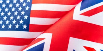 Two American and British flags are close together representing the strong trade ties between the US and Europe.
