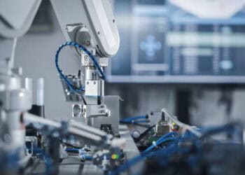 A robot is boosting productivity on a machine in a factory.