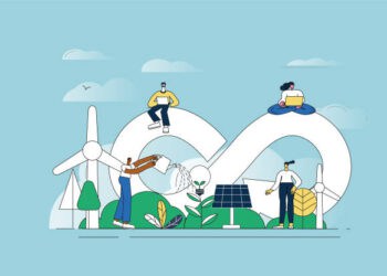 A group of people are sitting on a green field with wind turbines, demonstrating their commitment to the EU Environmental Agenda.