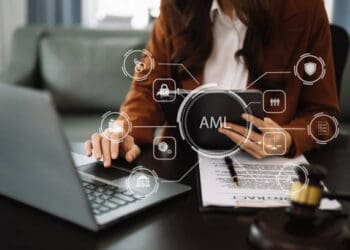 A woman, employed by TD Bank, is sitting at a desk with a laptop in front of her.