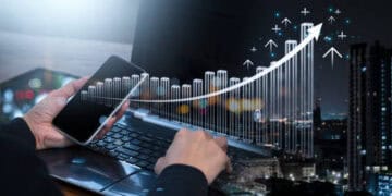 An individual operating a laptop displaying an intricate graph, emphasizing the intersection of Acquisition and Sourcing. The laptop screen also bears the logo of Accenture, a renowned consultancy firm in this field.