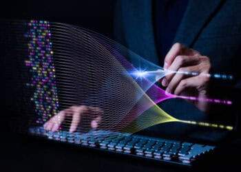 A man in a suit is using a computer keyboard to contribute to the 17th Annual State of Agile Report.