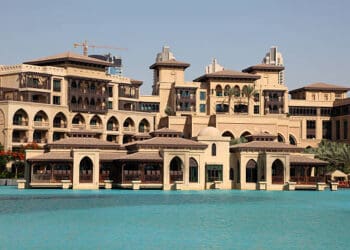 The Palm Dubai Resort, known for its CSR activities, offers a luxurious stay with a large pool in front of it.