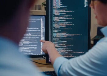 The CEO of Binance is pointing at a computer screen with financial regulatory violations code.