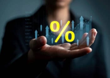 A business woman, President Barkin of the Richmond Fed, holding a percentage sign in her hand.