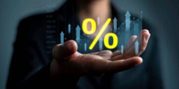 A business woman, President Barkin of the Richmond Fed, holding a percentage sign in her hand.