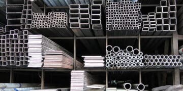 Various steel pipes and tubes are stacked in a warehouse, highlighting the impact of UK's WTO steel import tariffs.