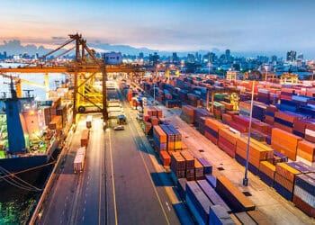 A view of a container port at dusk, highlighting the impact of trade barriers on UK SMEs.