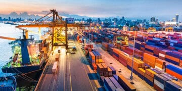 A view of a container port at dusk, highlighting the impact of trade barriers on UK SMEs.