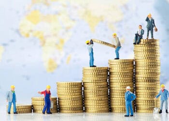 A group of figurines standing on top of stacks of coins, analyzing year-end economic data.