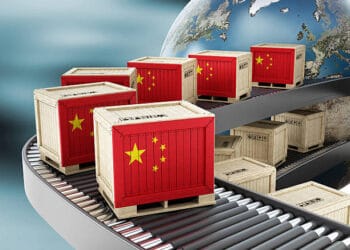 Chinese flags on a conveyor belt symbolize the impact of global trade and recent import-export tariff adjustments in China.