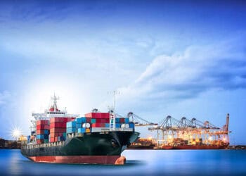 A large container ship imported EVs is docked in the ocean, benefiting from reduced tariffs in India.