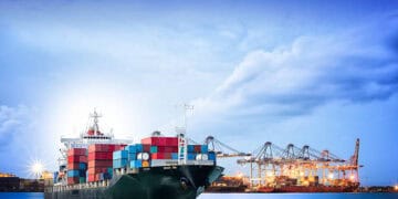 A large container ship imported EVs is docked in the ocean, benefiting from reduced tariffs in India.