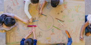 A group of children at the Utah International Leadership Academy showcasing their foreign relations skills by collaboratively drawing on a piece of paper.