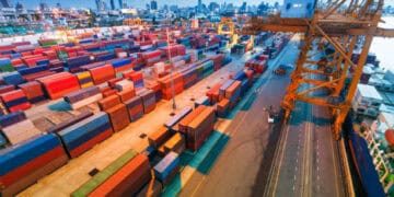 An aerial view of a container port at dusk, showcasing the bustling activities related to the Asia-Europe Trade Route.