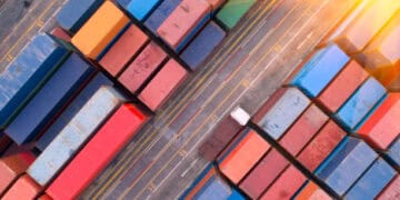 An aerial view of containers in a container yard located in the Red Sea, highlighting the connection between global trade and potential supply chain disruptions.