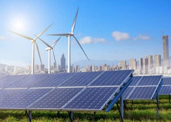 Solar panels and wind turbines in a city, driven by clean energy legislation.