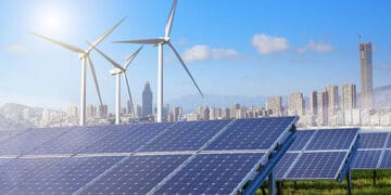 Solar panels and wind turbines in a city, driven by clean energy legislation.