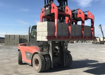 A red forklift with a load of bricks on it, used by Big 5 Construct Saudi and equipped with B&B Attachments.